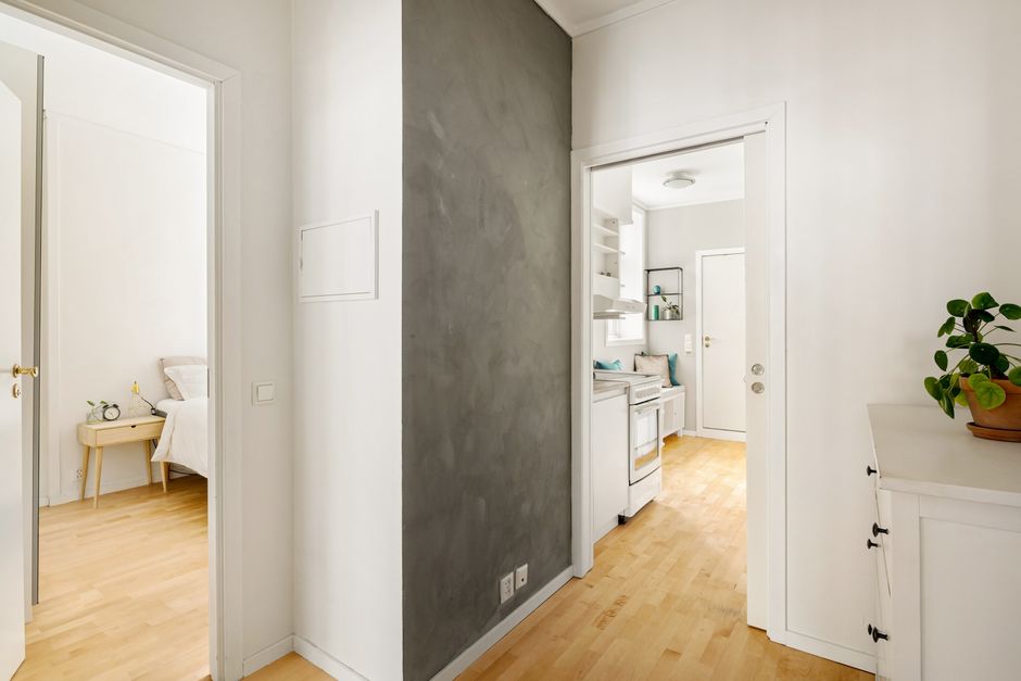 Crop anonymous housekeeper in yellow gloves cleaning white tiled wall using rag in bathroom